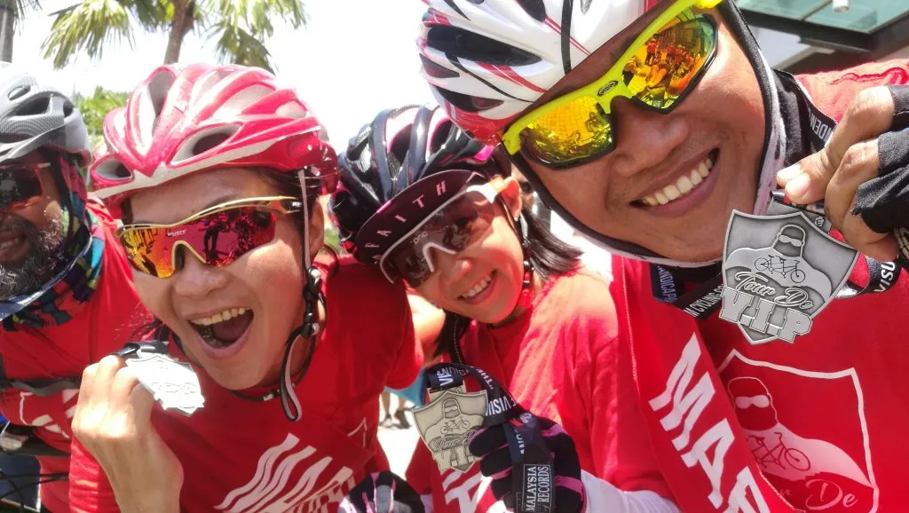 Cyclists wearing custom event jerseys and finisher medals